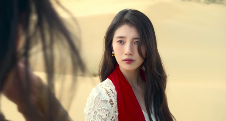 Ki Ga-young no deserto, com o cabelo cobrindo parte do rosto