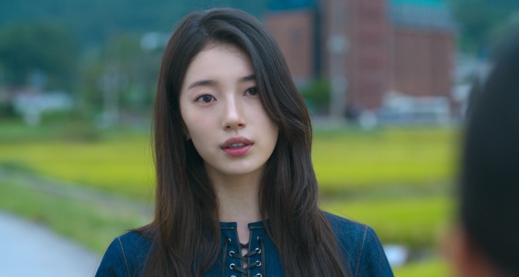 Ki Ga-young conversando com alguém, com um prédio escolar ao fundo