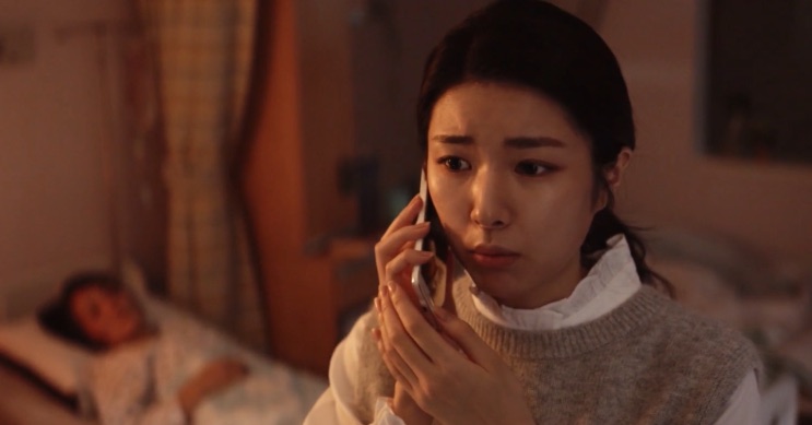 Na Yi-hyeon ao telefone no quarto do hospital