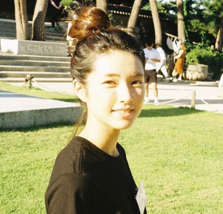 Ha Young num parque, sorrindo