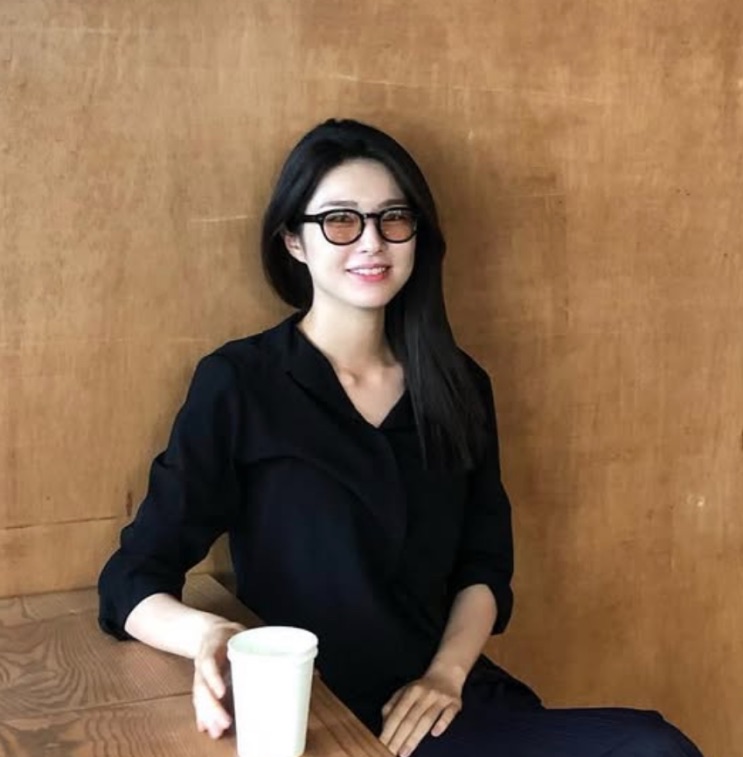 Ha Young de óculos, sentada