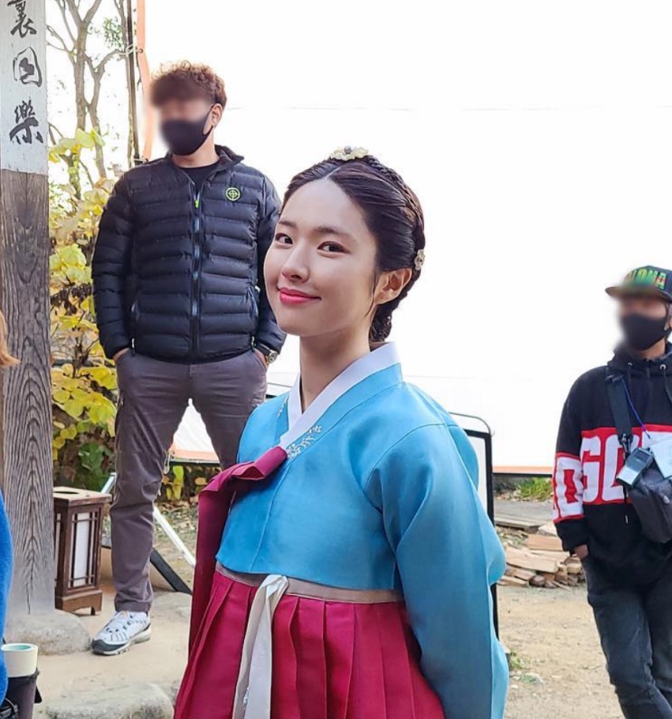 Ha Young de hanbok azul num set de gravação