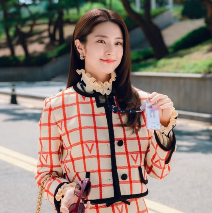 Go Eun-sae de blazer xadrez segurando o crachá de promotora
