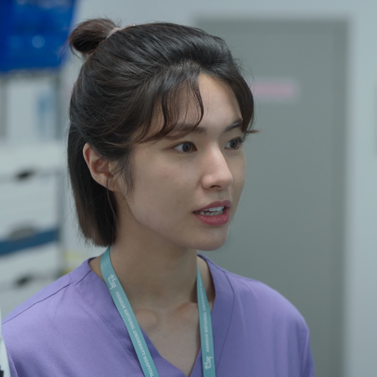 Close de Cheon Jang-mi de uniforme roxo, em Heróis de Plantão
