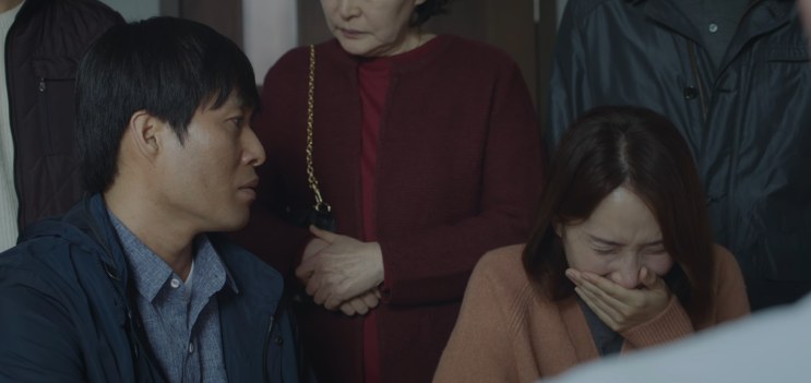 O marido, a esposa e a filha chorando dentro do consultório