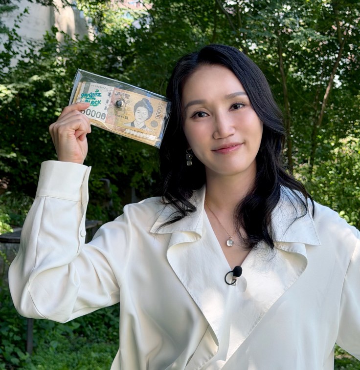 Park Bo-kyung ao ar livre segurando o cheque de prêmio do programa