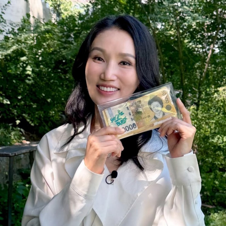 Park Bo-kyung sorrindo com o cheque de prêmio nas mãos