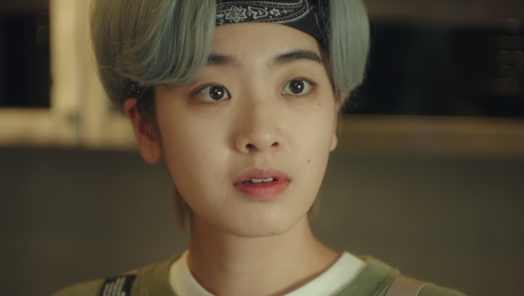 Close de Ma Hyun-yi de bandana preta, falando na cozinha do Danbam