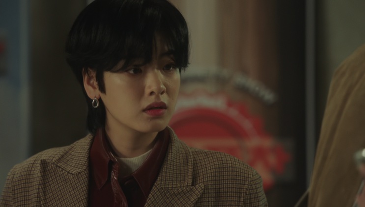 Ma Hyun-yi de cabelo preto curto e casaco xadrez, de perfil