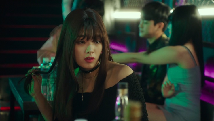 Ma Hyun-yi dançando na pista, com luzes neon ao fundo
