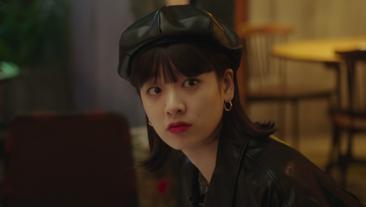 Ma Hyun-yi de boina, sentada em um ambiente interno