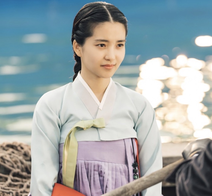 Kim Tae-ri mirando um rifle, com o rosto concentrado, no papel de Go Ae-sin