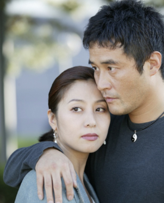 Casal abraçado ao ar livre, em cena do dorama South of the Sun