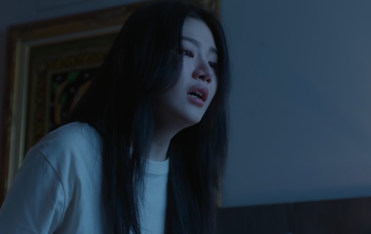 Ju Hye-ri à noite, com o rosto assustado, diante da tela de um computador