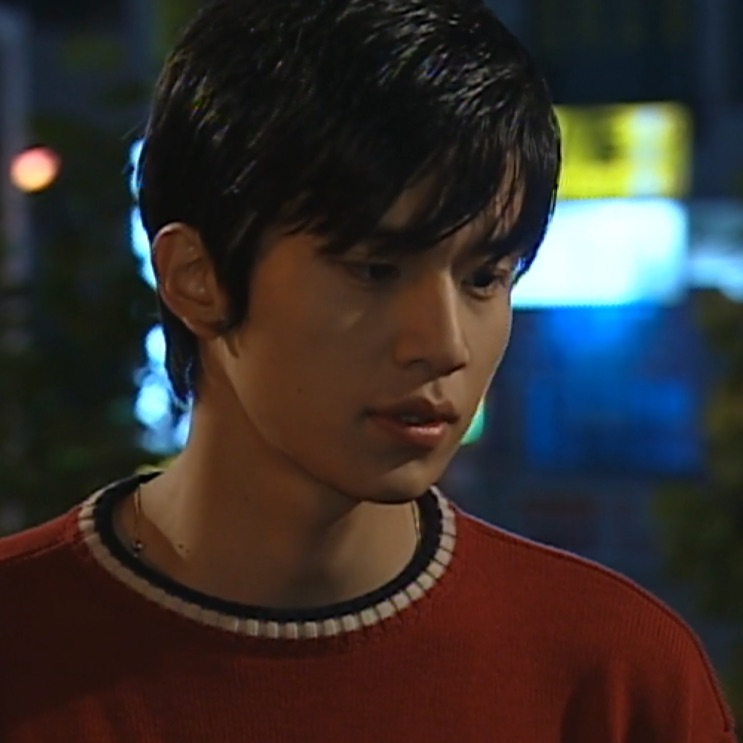 Lee Dong-wook jovem, no início da carreira, de suéter vermelho