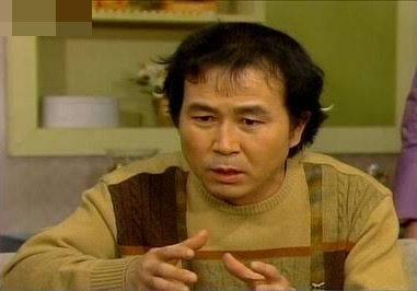 Ma Pae sentado na sala, gesticulando com as mãos enquanto conversa