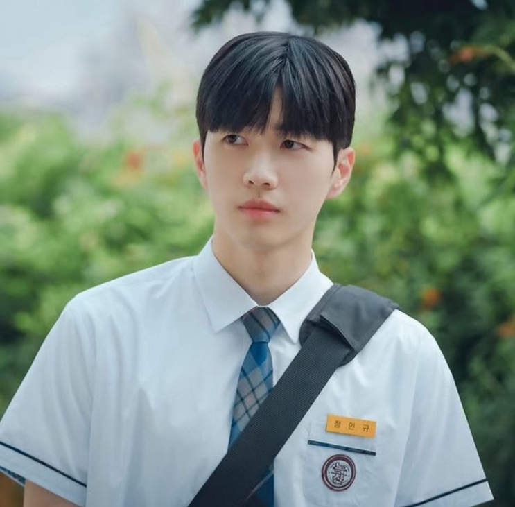Kang Hoon de uniforme escolar branco e gravata, ao ar livre