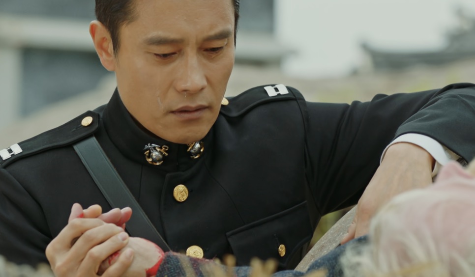 Lee Byung-hun de uniforme militar, de cabeça baixa, segurando uma mão, no papel de Eugene Choi