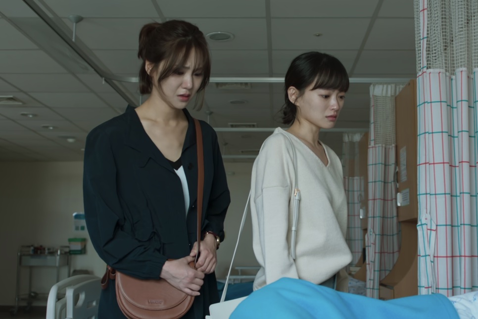 A Han-ju e a Jin-joo num quarto de hospital, olhando preocupadas para a cama