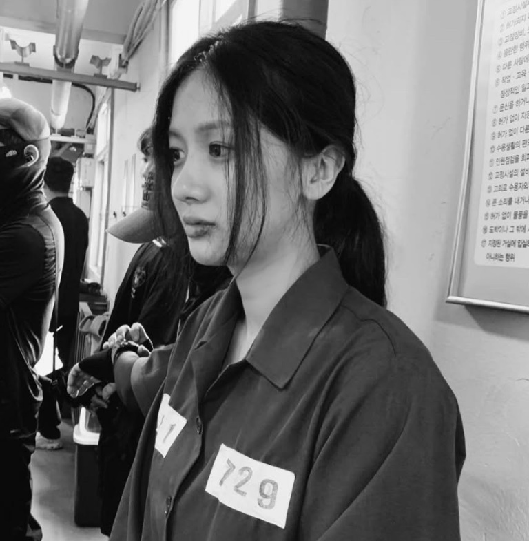 Foto em preto e branco da Song Su-yi de uniforme de presidiária, nos bastidores de Turbilhão