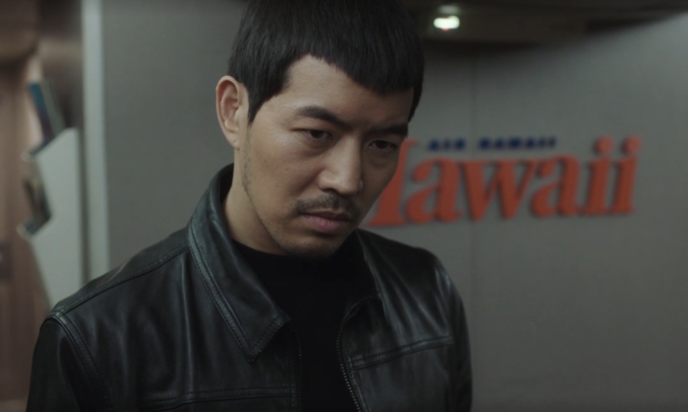 Lee Sang-yoon de jaqueta de couro preta, com expressão fechada, no papel do Ri Cheol-seung em Okay! Madam