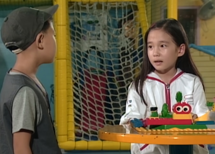 Su-ji conversando com Jung-bae, de boné virado para trás, no parquinho