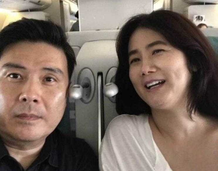 Shim Eun-ha ao lado do marido, os dois sorrindo dentro de um avião