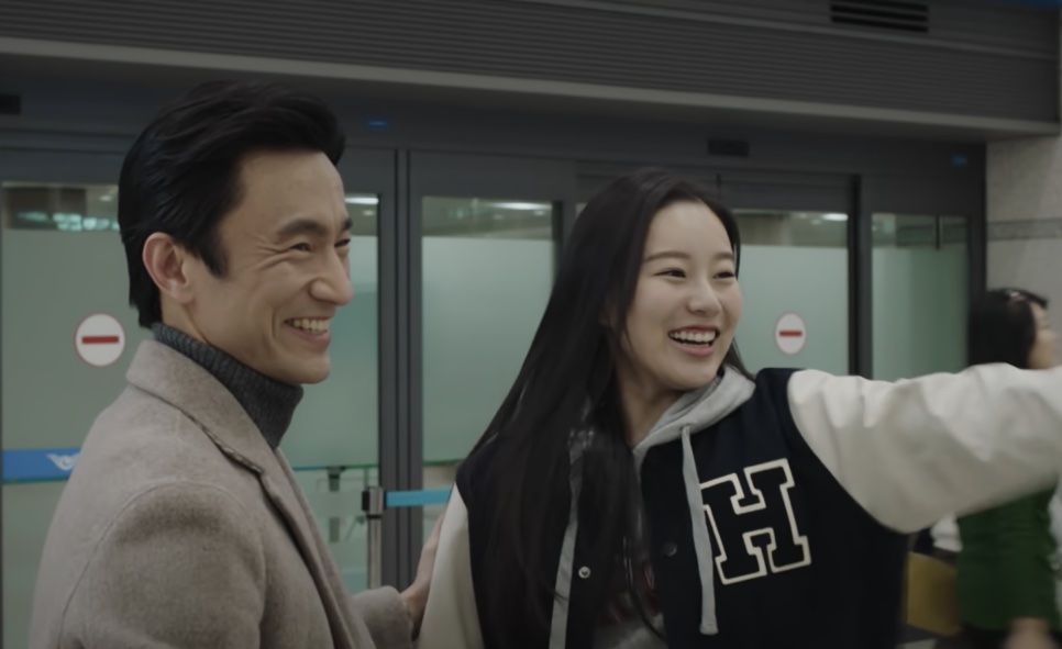 Cha Min-hyeok sorrindo ao lado da Se-ri, que abre os braços no aeroporto