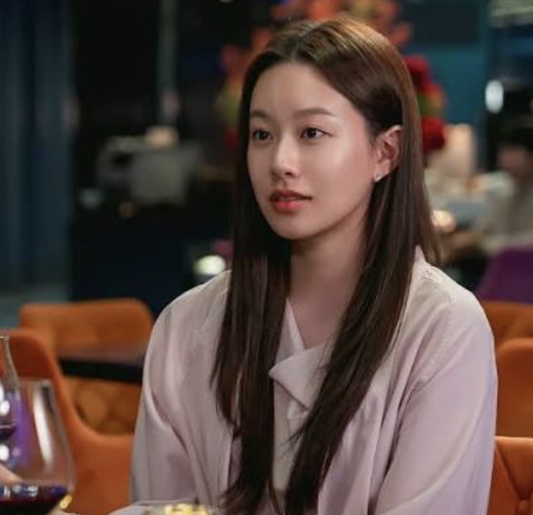 Park Yoo-na de blusa rosa-clara em um restaurante, no papel de Han Gyu-yeong em Love Is Coming