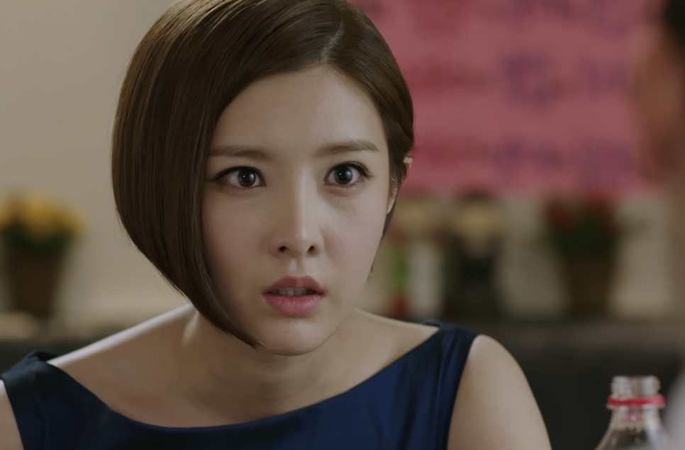 Close do rosto de Tae Yi-ryung, com uma parede rosa desfocada ao fundo