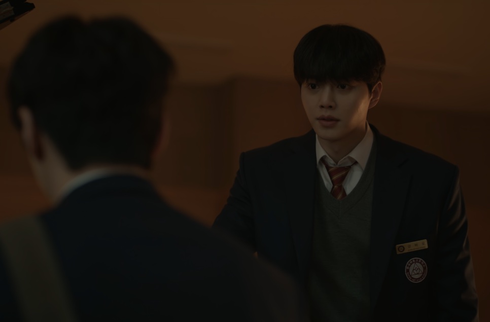 Um dos protagonistas de Quatro Mãos, Duas Sonatas, de uniforme escolar, de frente para o outro, que aparece de costas