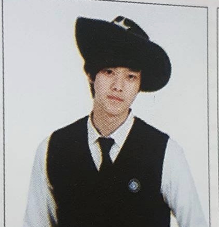 Foto antiga do Song Kang de colete preto, gravata e chapéu de aba larga