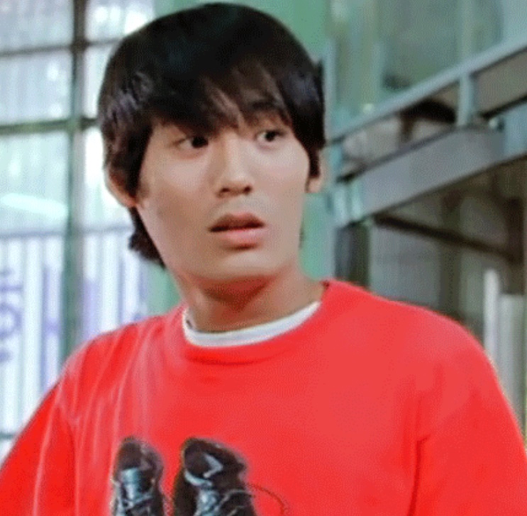 Choi Dae-hoon em cena antiga, de camiseta vermelha
