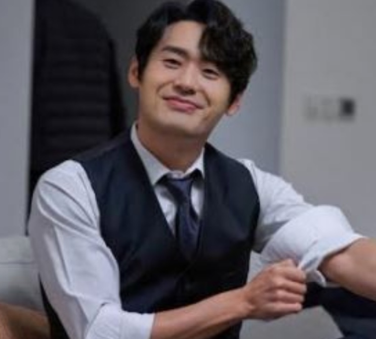 Choi Dae-hoon em foto recente, de colete e camisa