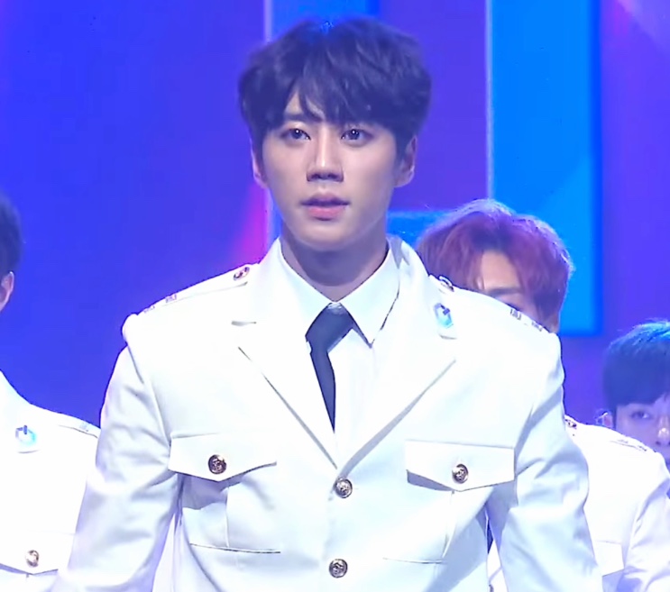 Lee Jun-young de uniforme branco no palco