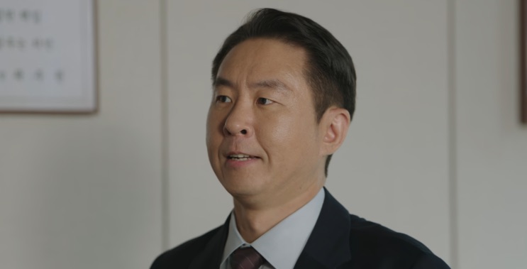 Lee Chung-won de terno, olhando de lado