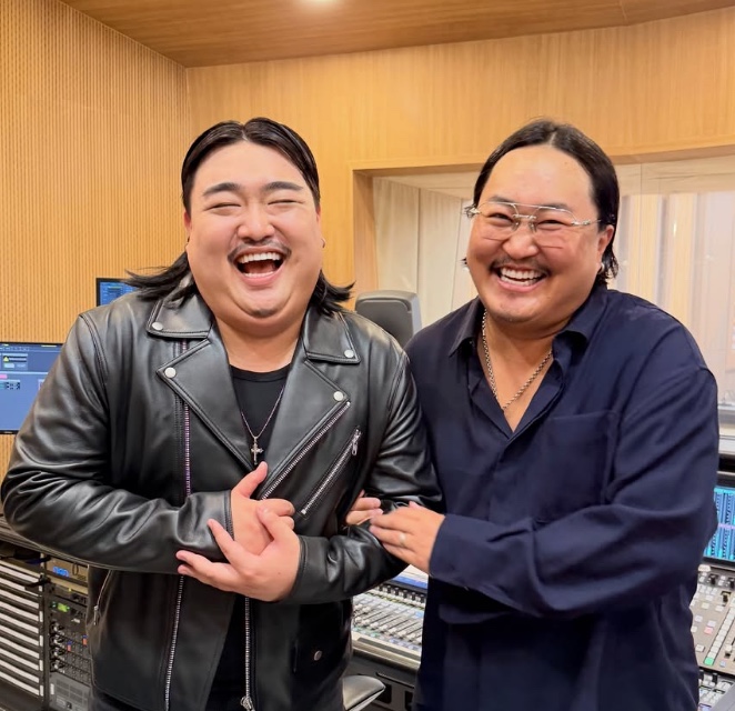 Kim Kyu-won rindo ao lado de outra pessoa em um estúdio