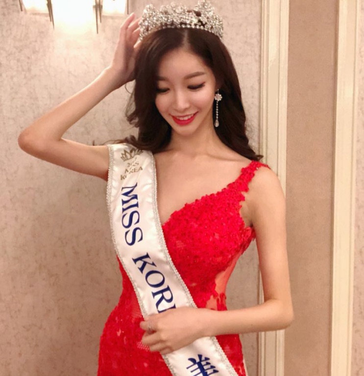 Lim Sa-rang de vestido vermelho, coroa e faixa de Miss Korea, com as mãos no cabelo