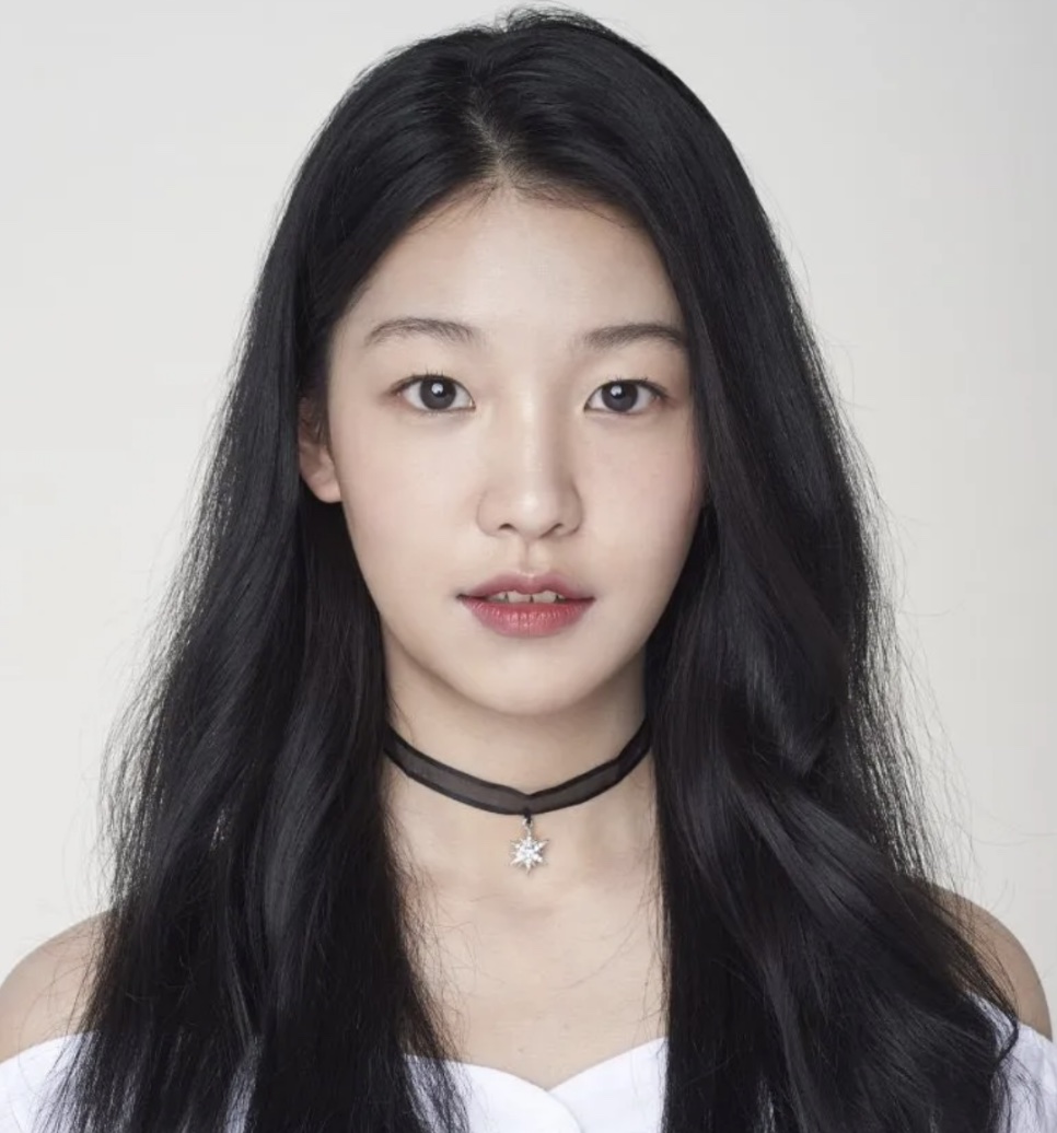 Foto de perfil da Baek Yae-in na época do OAHSIS, de cabelo comprido e gargantilha preta com estrela