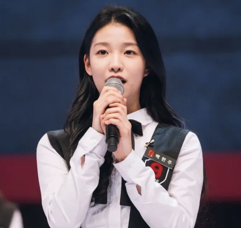 Baek Hyun-joo, hoje a atriz Baek Yae-in, falando ao microfone no palco do Mix Nine