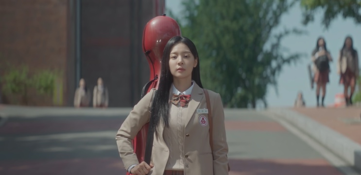 Choi Se-kyung com o violoncelo nas costas, de uniforme escolar