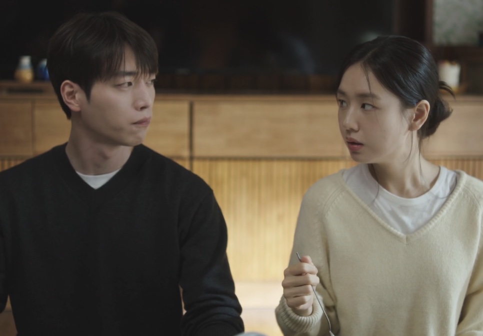 Seo Kang-joon e Ahn Eun-jin sentados à mesa, ela olhando para ele com uma colher na mão, em Um Amor Diferente do Seu