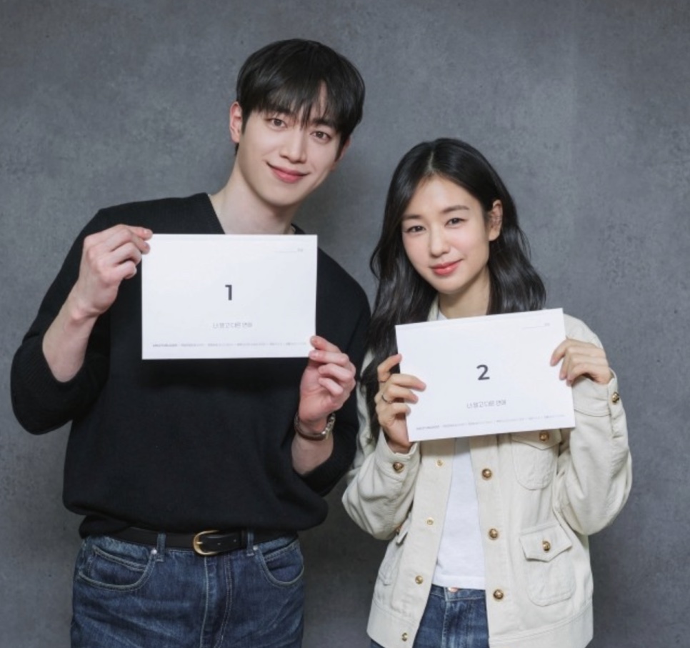 Seo Kang-joon e Ahn Eun-jin sorrindo e segurando os roteiros dos episódios 1 e 2 de Um Amor Diferente do Seu