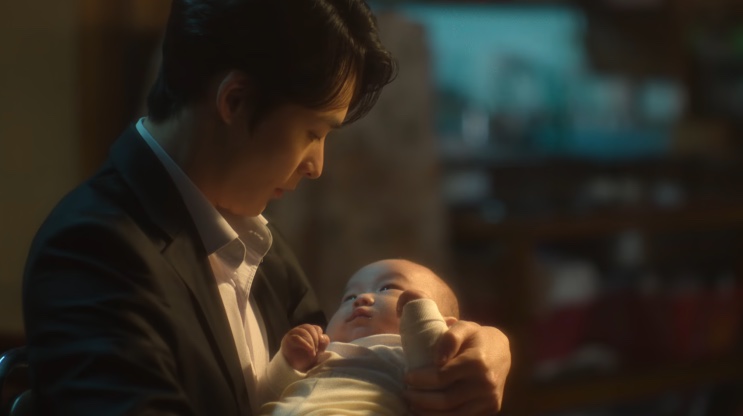 Baek Sang-gil com um bebê no colo