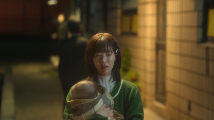 A mãe do Jang Tae-ha com o bebê no colo