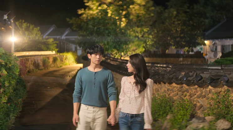 Tae-ha e Eun-sae num caminho da aldeia à noite