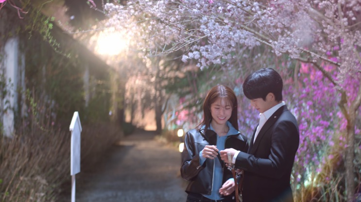 Túnel de flores iluminado, com Tae-ha e Eun-sae caminhando