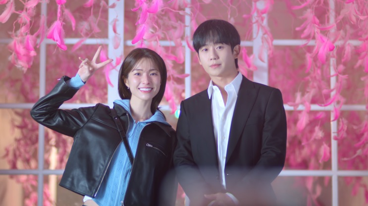 Eun-sae e Tae-ha diante de uma instalação de fitas cor-de-rosa