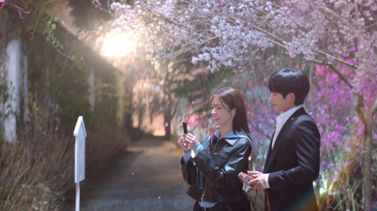 Eun-sae fotografando Tae-ha num caminho florido