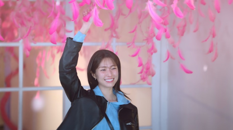 Eun-sae com o braço erguido sob a instalação cor-de-rosa